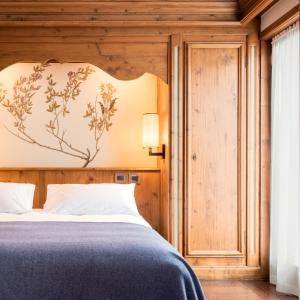 科尔蒂纳丹佩佐法洛里亚山Spa度假酒店的一间卧室配有一张带大床头板的床