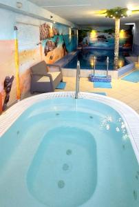 米兹多洛杰库拉布旅馆的一个带游泳池的房间里的一个大型热水浴缸