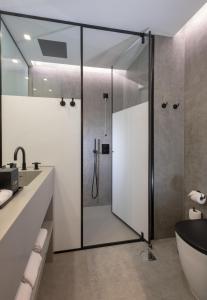 丰沙尔Hotel Cajú的带浴缸和盥洗盆的淋浴浴室