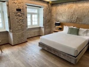 波尔图Oca Ribeira do Porto AT的一间卧室设有一张大床和两个窗户。