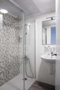扎哈拉Hotel Tugasa Arco de la Villa的一间带玻璃淋浴和水槽的浴室