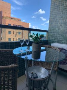 若昂佩索阿Tambaú Beach Paradise的阳台上的桌子上放着两杯酒和盆栽植物