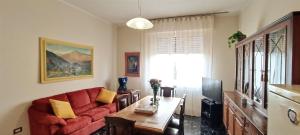 帕尔马La Casa di Amelie的客厅配有红色的沙发和桌子