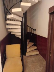 达喀尔Iris Hotel的一条带黄色椅子的楼梯和一个螺旋楼梯