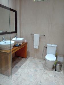 达喀尔Iris Hotel的一间带水槽、卫生间和镜子的浴室