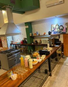 门多萨Clover Hostel的厨房配有带食品和酒杯的桌子