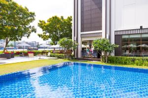 曼谷宜必思曼谷河畔酒店的大楼前的游泳池