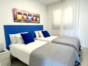梅罗那瑞斯Bahia Meloneras Vista Golf的蓝色和白色的客房内的两张床