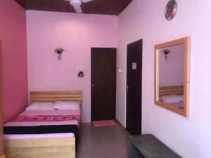 科伦坡微风天堂酒店的一间小卧室,配有一张床和镜子