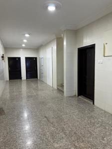 乌姆莱季AlSultan Apartments的一间空房间,有白色的墙壁和黑色的门