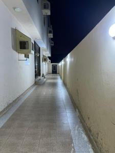乌姆莱季AlSultan Apartments的建筑里空空的走廊,墙上有电视