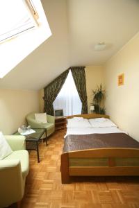 弗罗茨瓦夫省孔蒂Pokoje hotelowe Azyl的一间卧室配有一张床、一张沙发和一个窗口