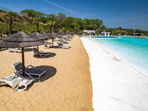 Estepona2152-Modern apt with private beach的游泳池旁带椅子和遮阳伞的海滩