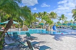 那不勒斯Luxury Golf Villa in Beautiful Lely Resort with Pool的度假村内带椅子和棕榈树的游泳池