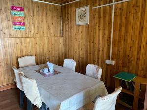 大吉岭Ridge View Chalet Homestay的一间带桌子和白色椅子的用餐室