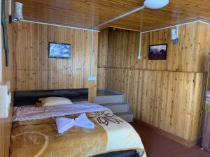 大吉岭Ridge View Chalet Homestay的卧室配有木墙内的一张床