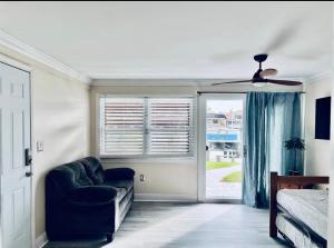 珊瑚角Cheerful home with one bedroom的一间带沙发和吊扇的卧室
