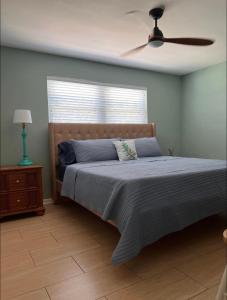 珊瑚角Cheerful home with one bedroom的一间卧室配有一张带风扇和窗户的床。