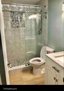 珊瑚角Cheerful home with one bedroom的一间带卫生间和玻璃淋浴间的浴室