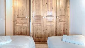 莱斯Saplan Real Estate CARLAC的卧室配有带床和门的木制衣柜