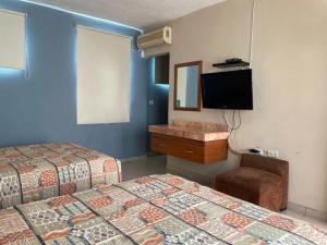 比亚埃尔莫萨Hotel Santo Domingo Express的酒店客房设有两张床和一台平面电视。