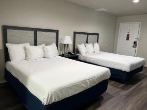 GrahamSalt Creek Lodge的配有白色床单的酒店客房内的两张床