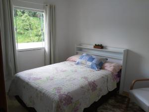 多明戈斯马丁斯QUARTO CASA FREDERICO的一间小卧室,配有一张带窗户的床