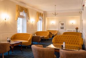 斯佩河畔格兰敦格兰特纹章酒店的一间备有橙色椅子和桌子的等候室