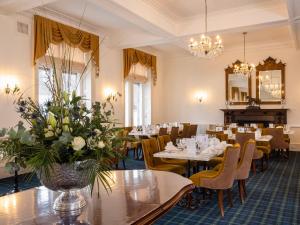 斯佩河畔格兰敦格兰特纹章酒店的餐厅设有桌椅和镜子