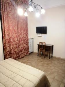 巴里hotel de rossi的一间卧室配有一张床、一张书桌和一台电视