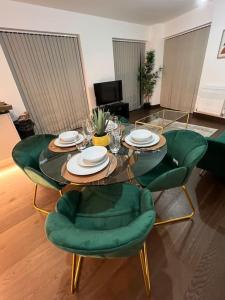 达特福德Dartford Lux Stay one bedroom apartment的客厅配有玻璃桌和绿色椅子