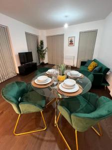 达特福德Dartford Lux Stay one bedroom apartment的客厅配有桌子和绿色椅子