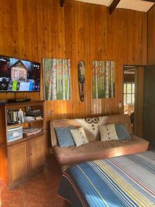 Río CuartoEquipped cottage in Laguna Hule的一间带沙发和电视的卧室