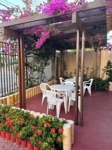 福塔莱萨Hotel Pousada Villa Marina的庭院配有桌椅和鲜花