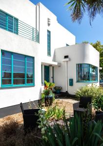 伯青顿Twentieth Century B&B的白色的房子,拥有蓝色的窗户和植物