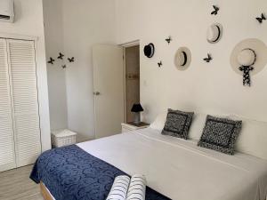 棕榈滩屠卡西塔阿鲁巴度假屋的卧室配有一张大床,墙上挂着黑色星星