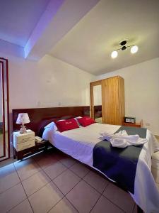库斯科Hotel Feimar的一间卧室配有一张带红色枕头的大床