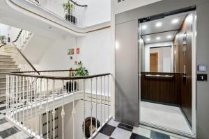 马拉加Malaga City Suites的走廊上设有通往门的楼梯