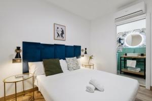 马拉加Malaga City Suites的一间卧室配有一张白色大床和蓝色床头板
