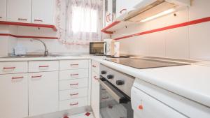托莱多El Rincón de las Cortes的白色的厨房配有水槽和微波炉