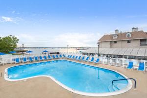 纽波特惠灵顿度假酒店的一座带蓝色椅子的大型游泳池和一座建筑