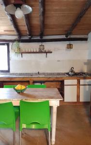 且乌塔Casita campestre的厨房配有木桌和绿色椅子