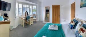 基督城Avon Beach Bed & Breakfast的一间卧室配有一张床、一张桌子和一个水槽