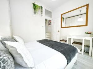 伦敦LUXURIOUS Terrace 2 Bedrooms in Relaxing Covent Garden Apartment的白色的卧室配有白色的床和镜子