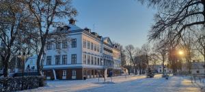 ÖsterfärneboGysinge Herrgård的白雪 ⁇ 街道上一座白色的大建筑