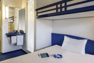 拉朗埃塔亚琛拉朗酒店的一间卧室配有一张带笔记本电脑和镜子的床