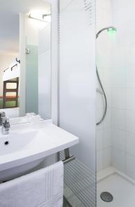 拉朗埃塔亚琛拉朗酒店的白色的浴室设有水槽和淋浴。