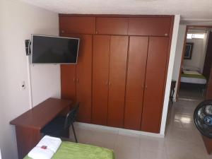 布卡拉曼加Habitar de Asis的一间卧室配有书桌、电视和橱柜。