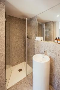 波尔图As Vizinhas Boutique Apartments的一间带水槽和玻璃淋浴的浴室