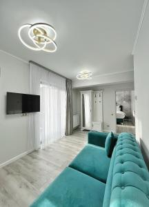 锡比乌Glam Studios的客厅配有蓝色的沙发和电视